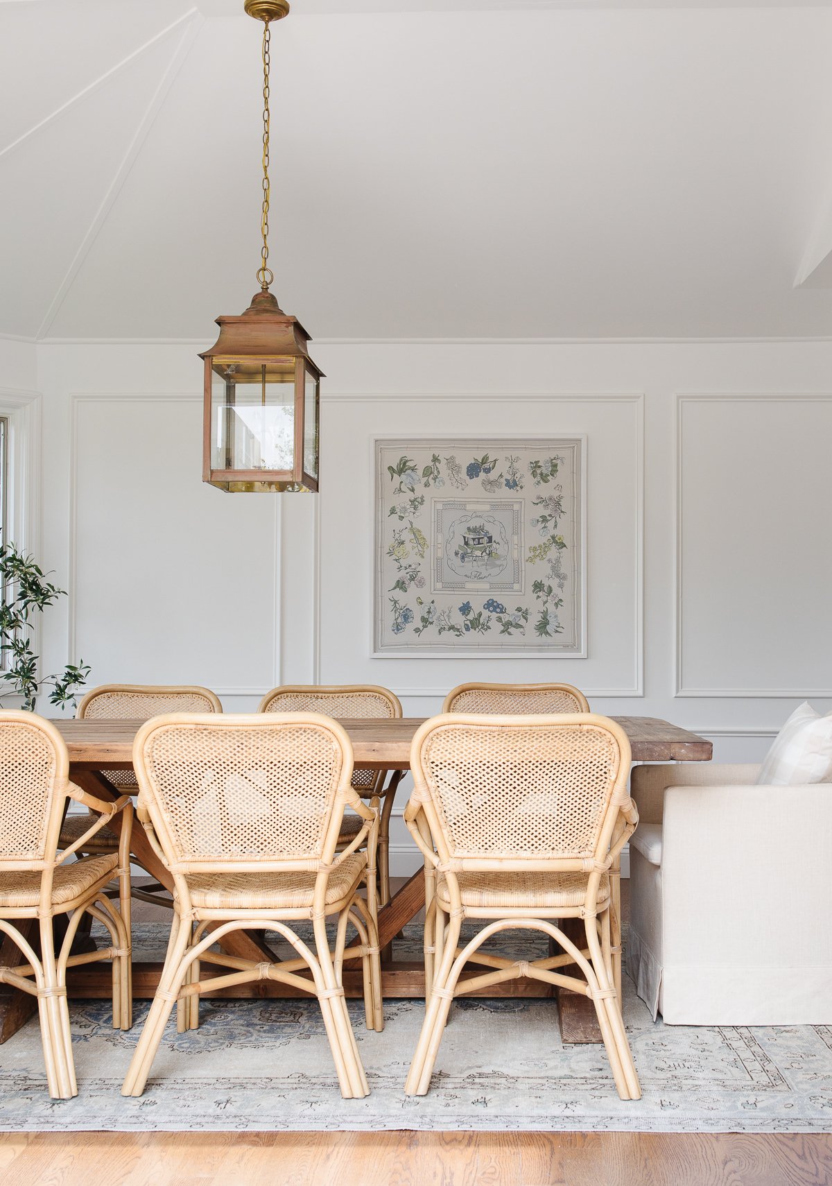 A white painted dining room with rattan chairs