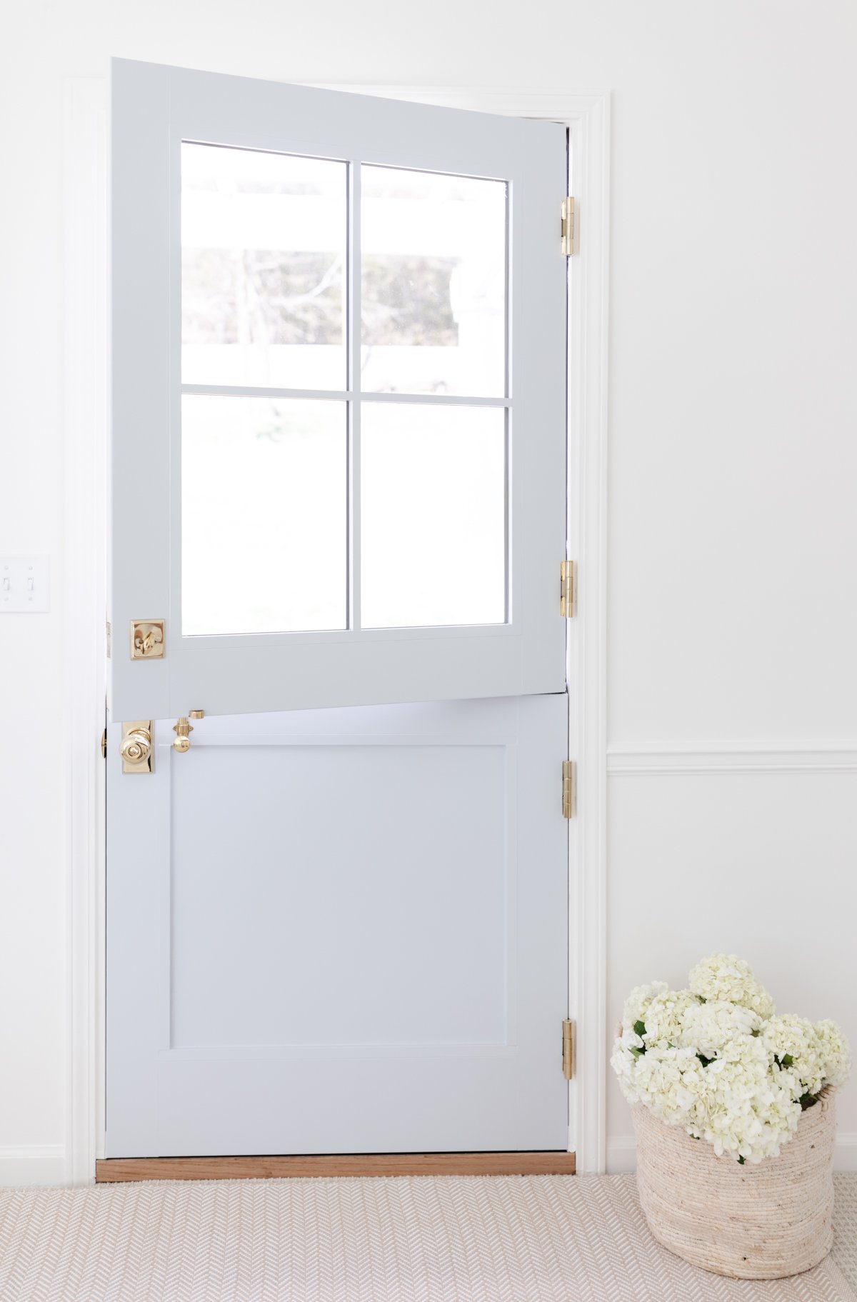 a blue Dutch door in a white room