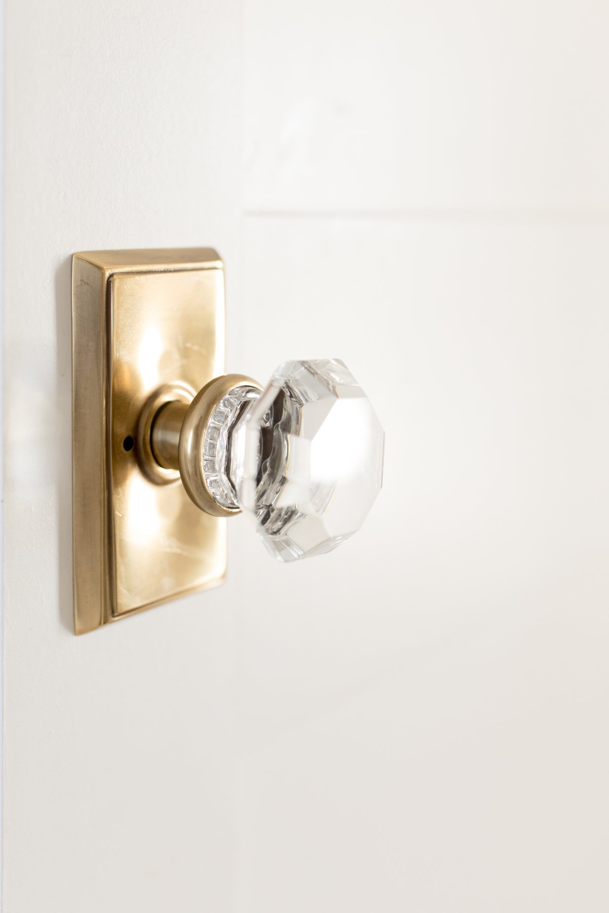 A white door with a brass and glass door knob