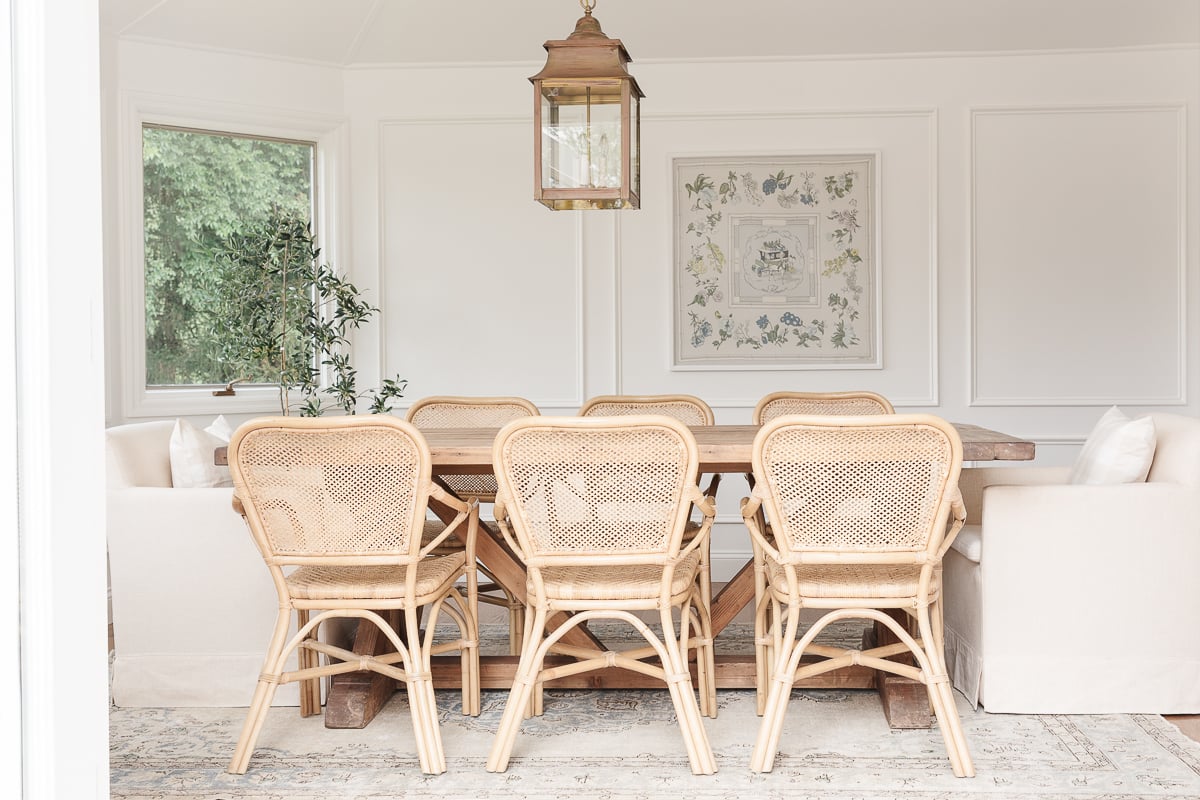 A white painted dining room with rattan chairs