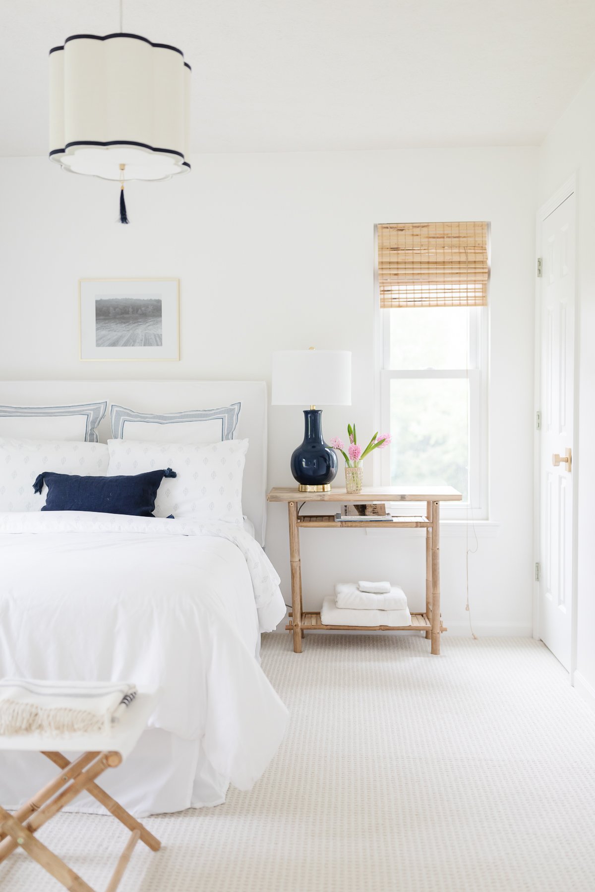 A white guest bedroom with navy accents