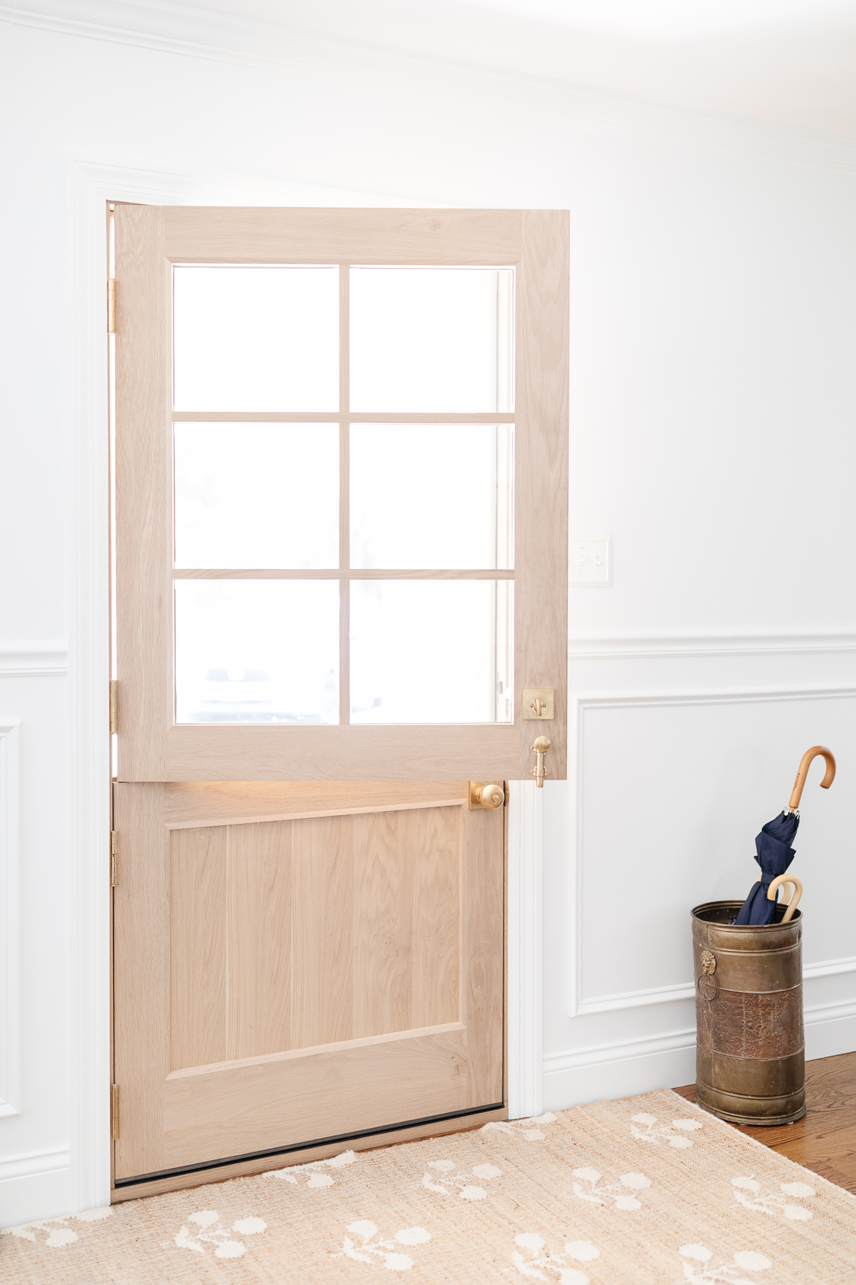 A light wood Dutch door in a white painted entryway