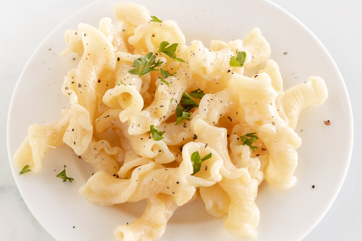 cheesy pasta on white plate