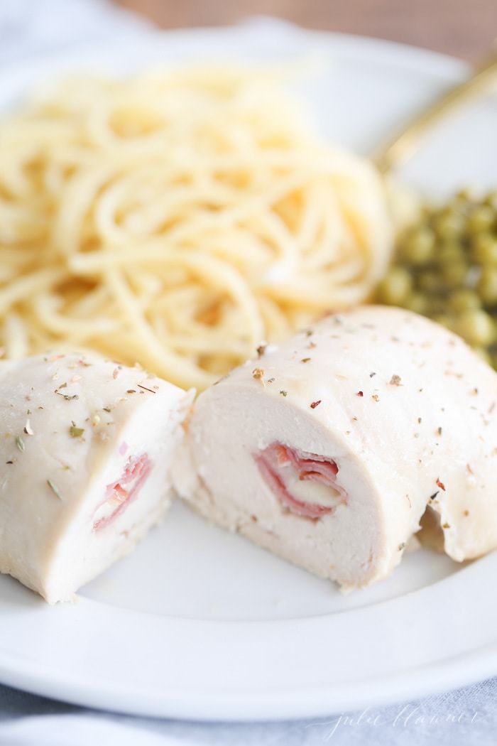 cheese stuffed chicken breast cut in half on a white plate