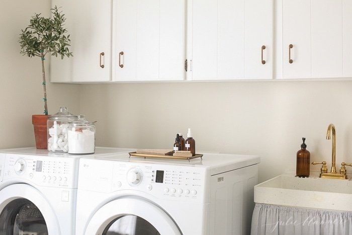 washer and dryer with white cabinets above