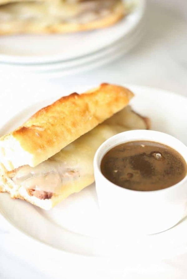best French dip sandwich recipe on white plate with au jus in white bowl