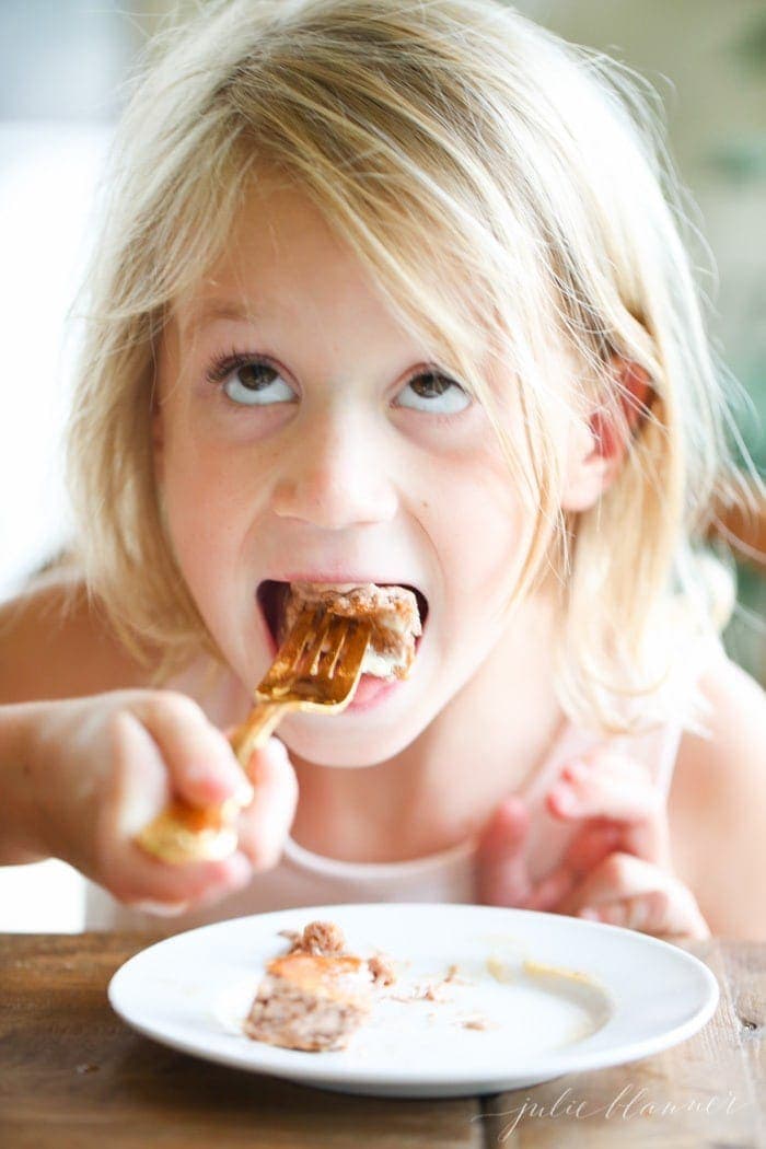 A little girl easting Chocolate Protein Pancakes