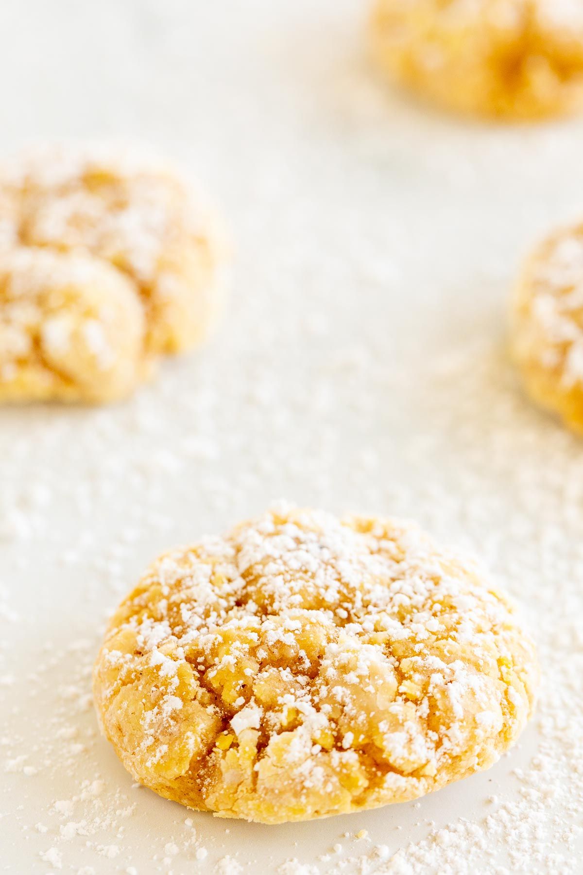 pumpkin gooey butter cookies topped with powdered sugar, laid out on a marble countertop