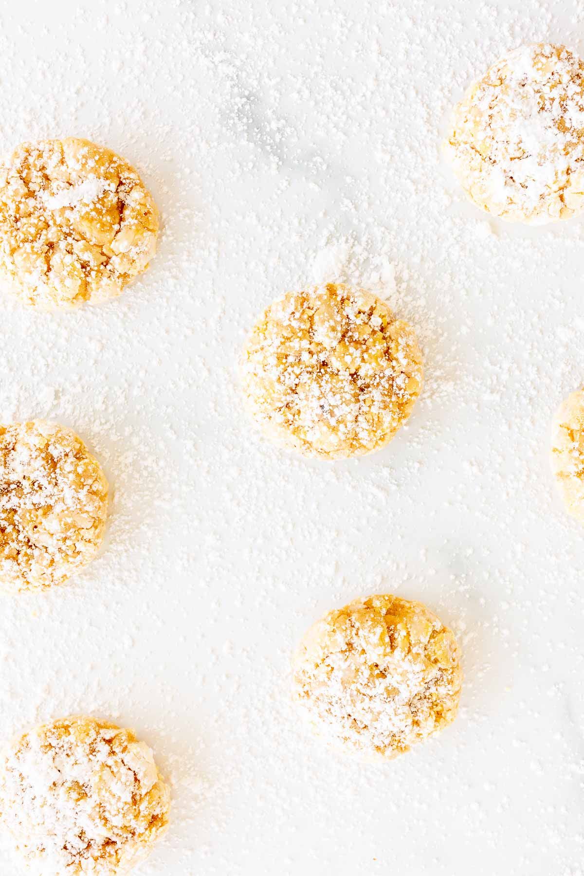 pumpkin gooey butter cookies topped with powdered sugar, laid out on a marble countertop