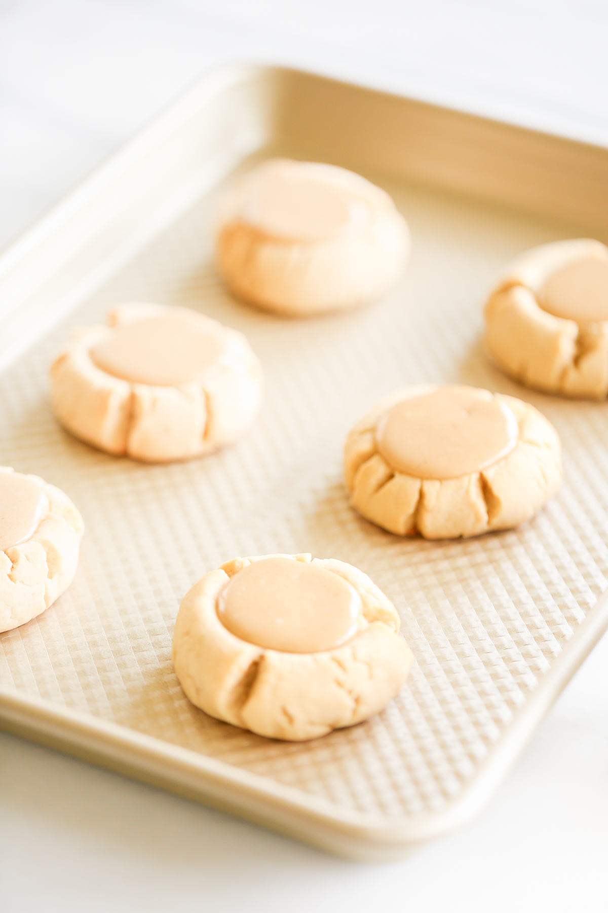 Caramel peanut butter cookies on a baking sheet.