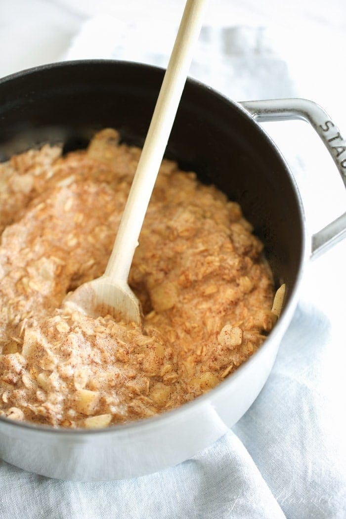 Oatmeal in a pan with a wooden spoon ready to serve