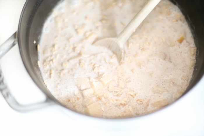 The cooked oatmeal in a pan with a spoon