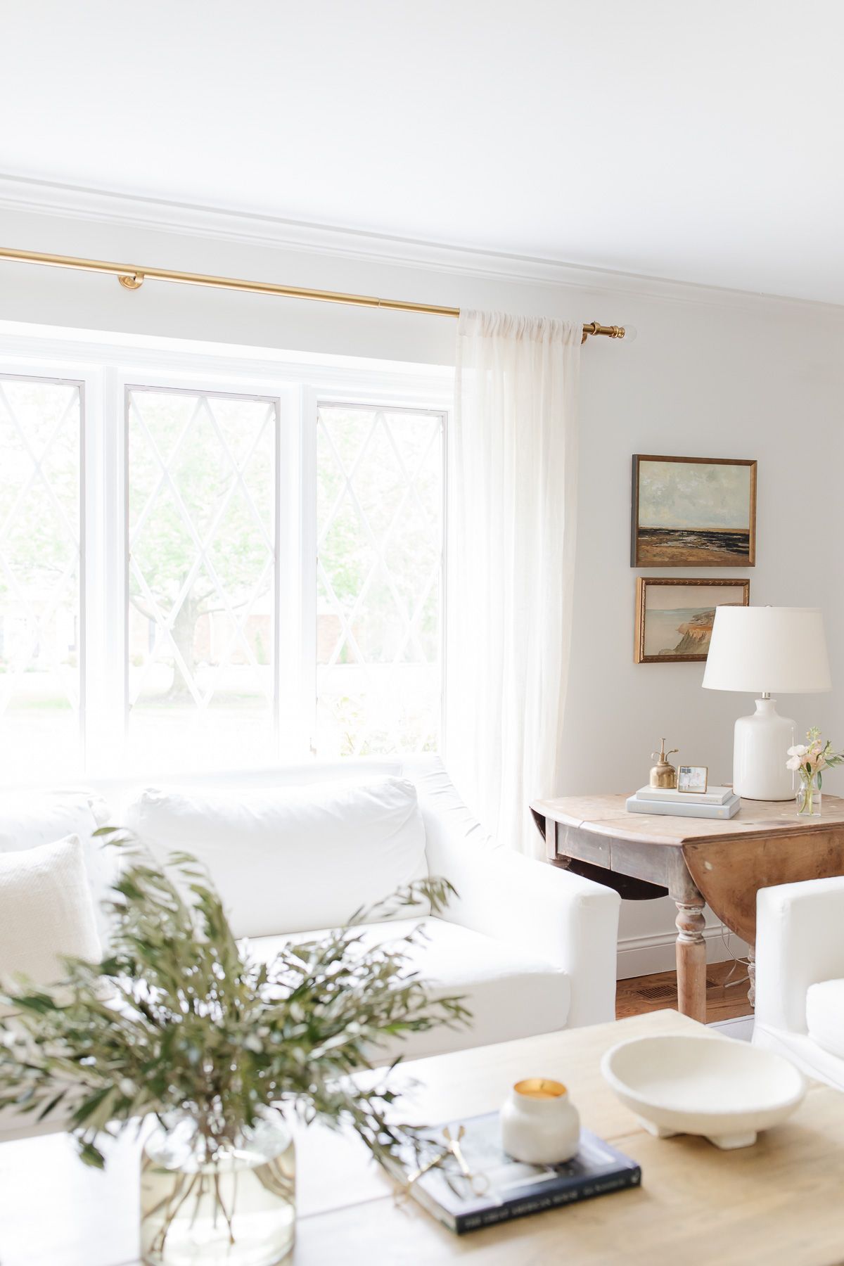 a living room with a white sofa and a neutral paint color on the walls