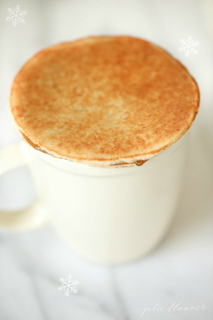 a white mug topped with a stroopwafel
