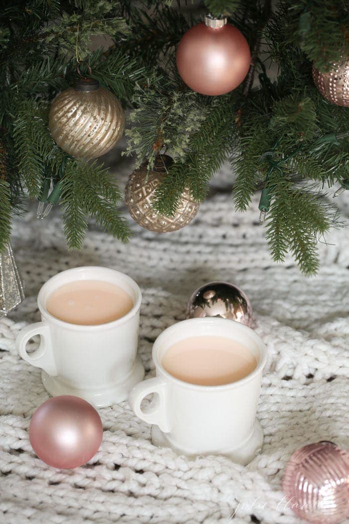 Two mugs of drink on a blanket