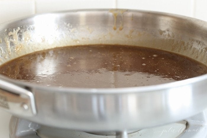 a silver pan on the stove with the filling for a stroopwafel recipe 