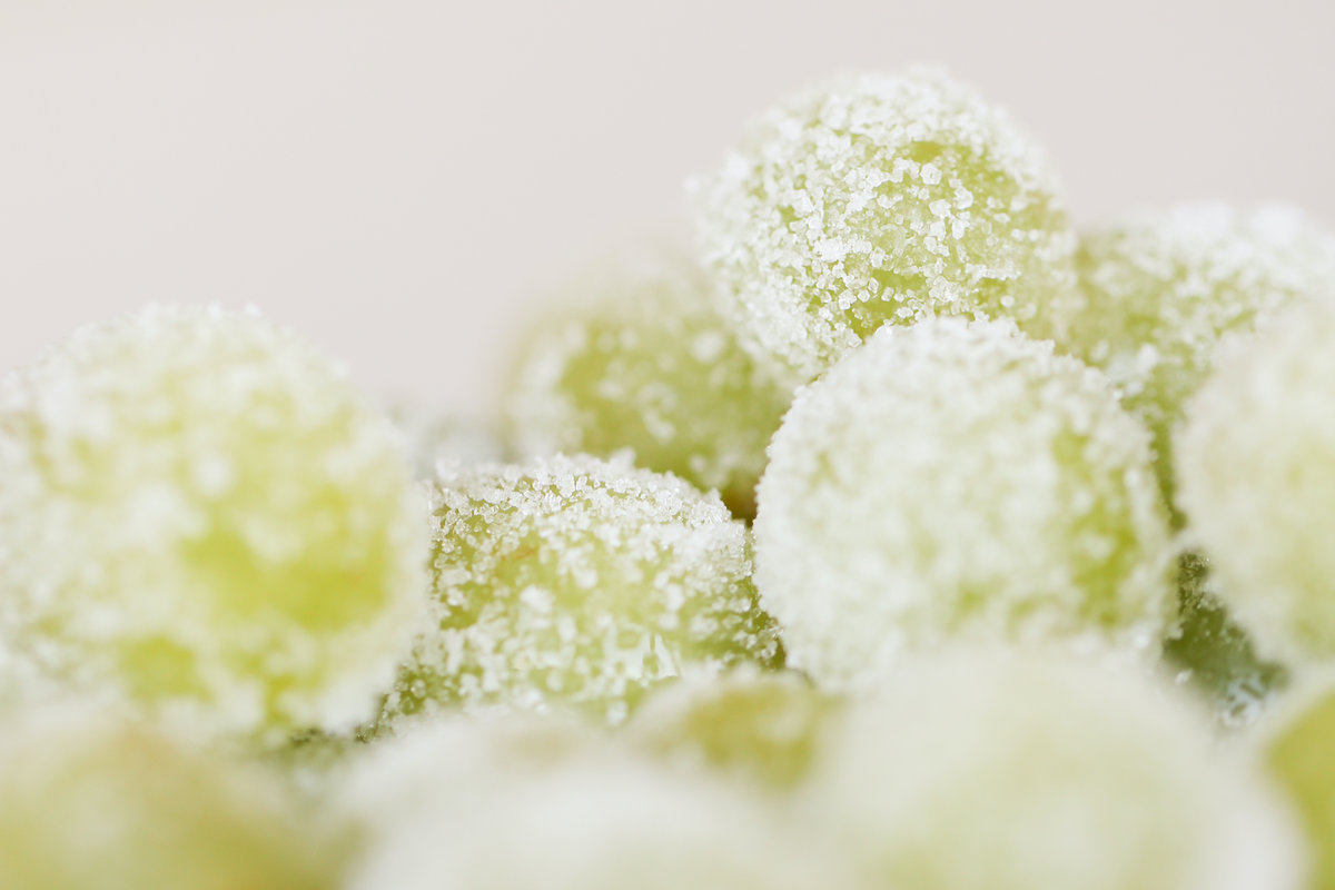 A white bowl of green sugared champagne grapes.