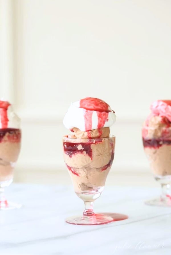 An easy trio of desserts in glasses with chocolate mousse, whipped cream, and raspberry sauce.