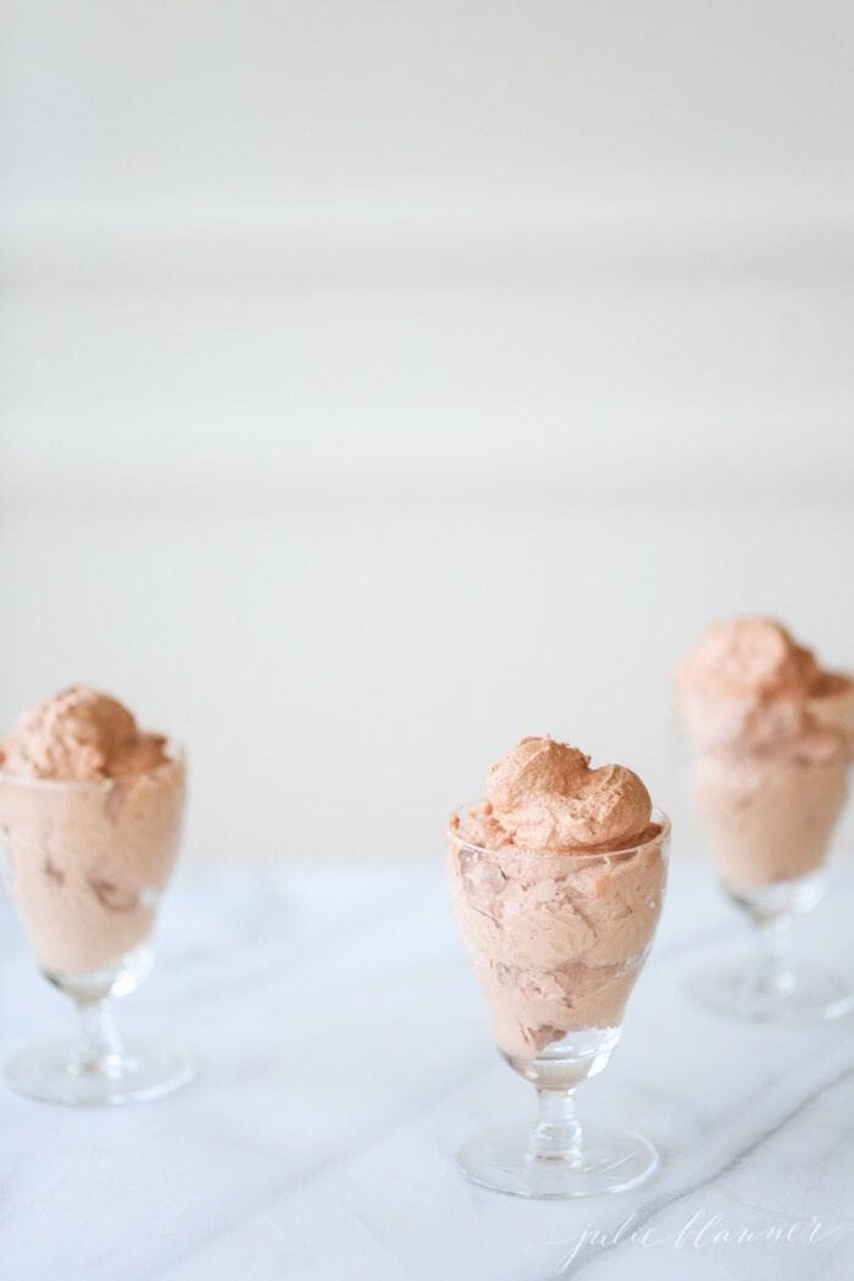 Easy chocolate mousse recipe served in glass cups on a marble table.
