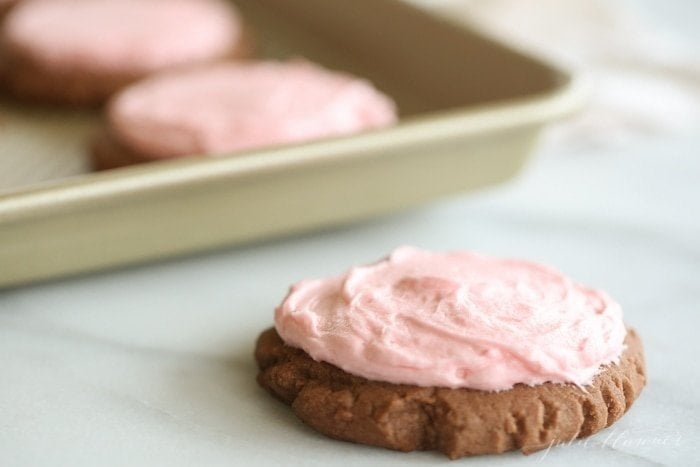 A cookie with pink icing