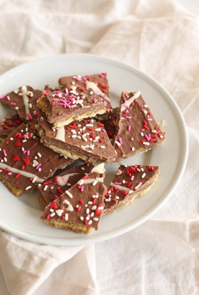 sprinkled toffee Valentine's Day candy on a white plate.