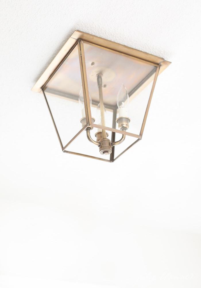 A brass lantern hall light mounted on the ceiling