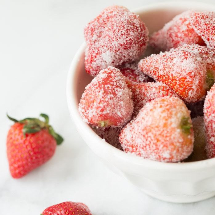 drunken strawberries, soaked in wine and rolled in sugar, in a white bowl