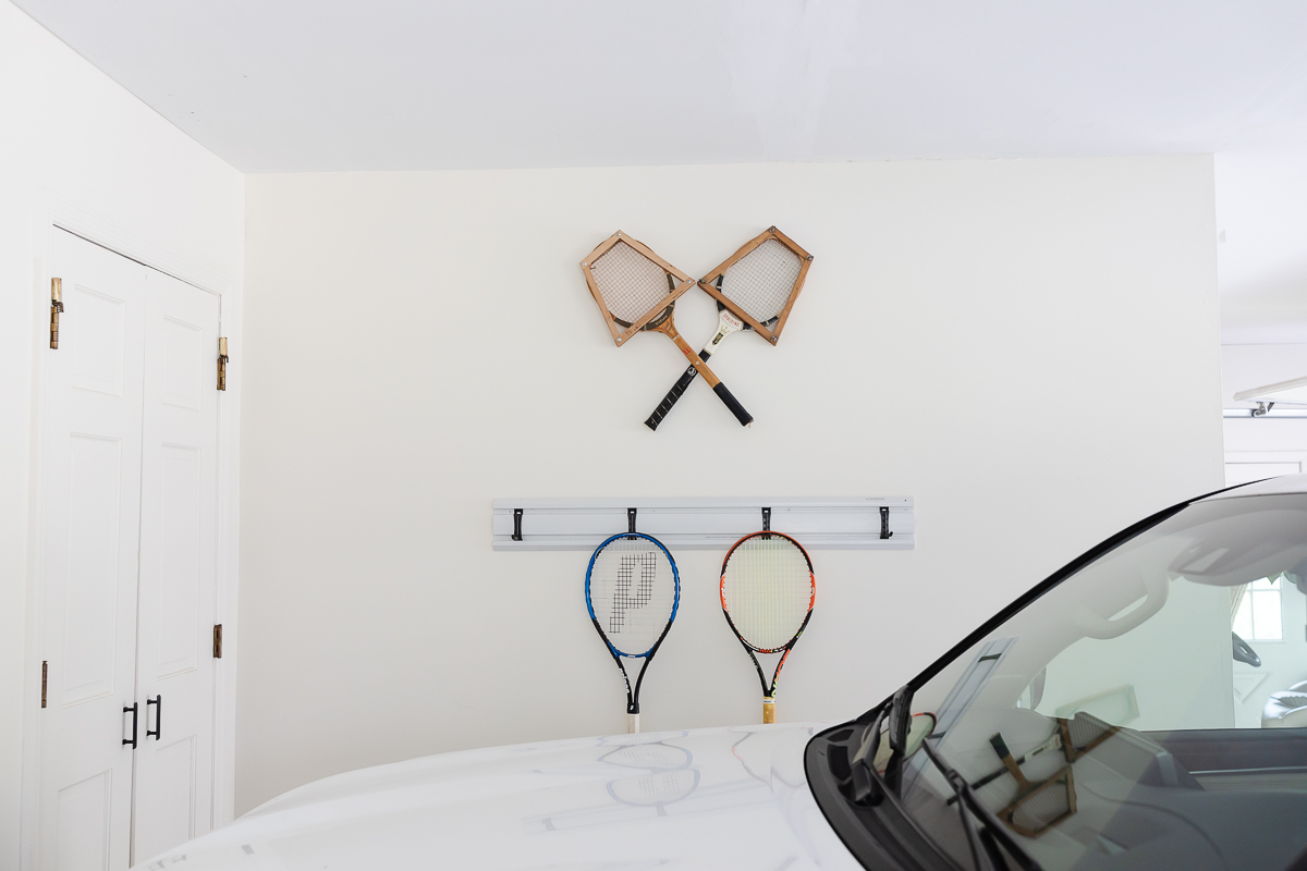 A white garage with a wall of garage organization hooks