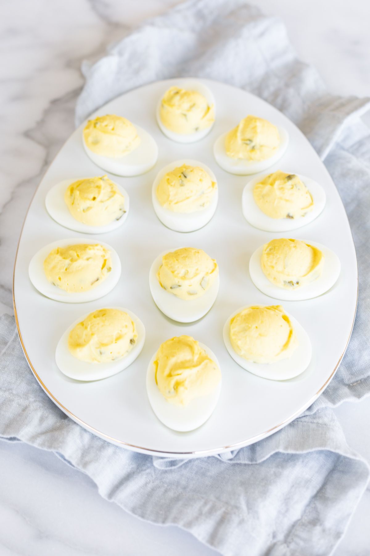 A white deviled egg platter featuring the world's best deviled egg recipe. 