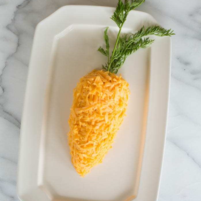 An Easter carrot cheeseball on a white platter