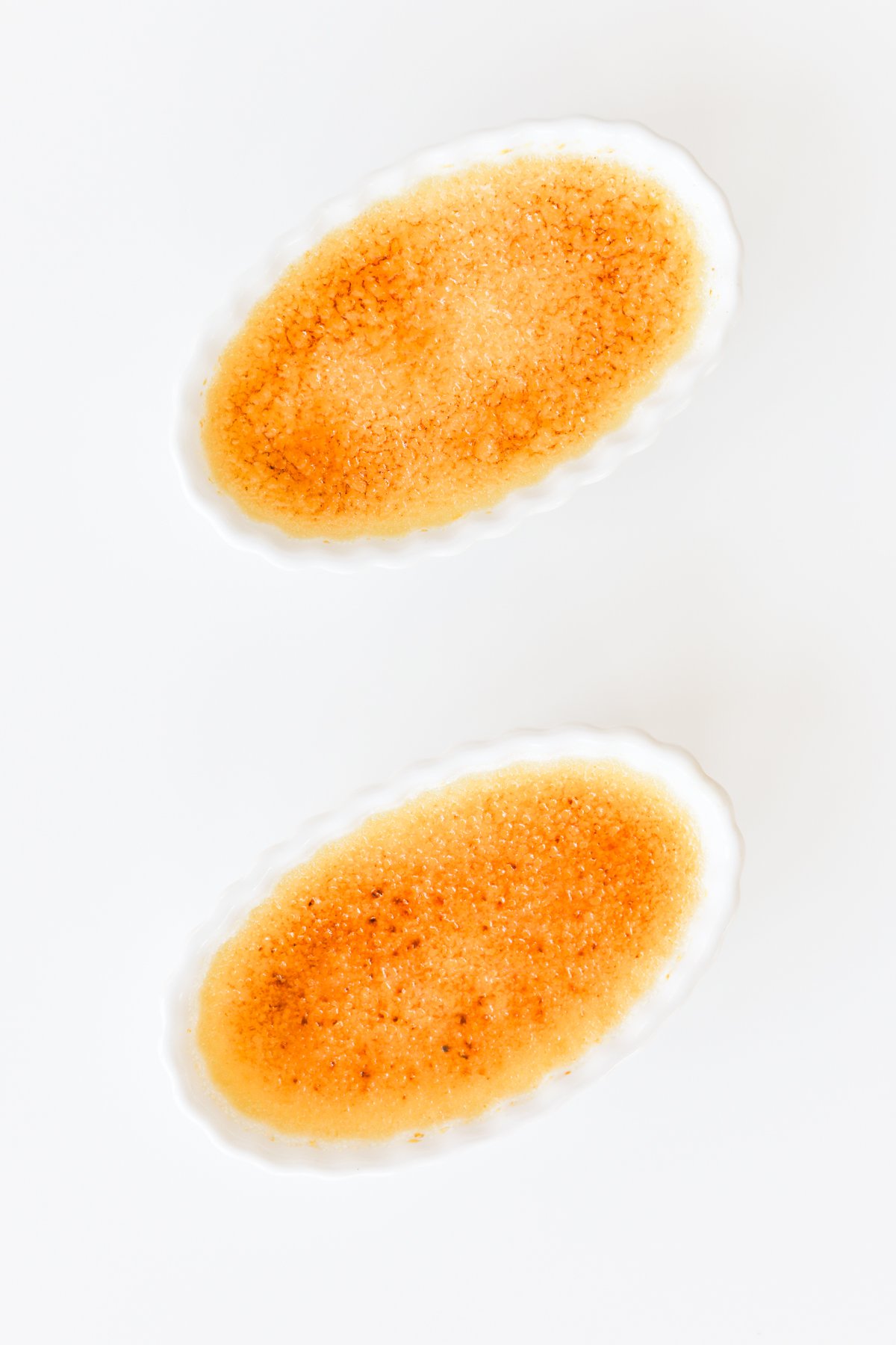 Two bowls of easy creme brulee on a white background.