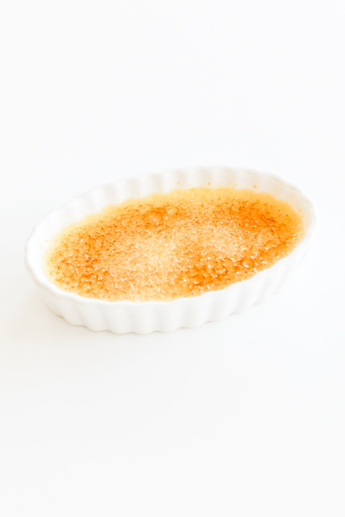 An easy creme brulee served in a bowl on a white surface.