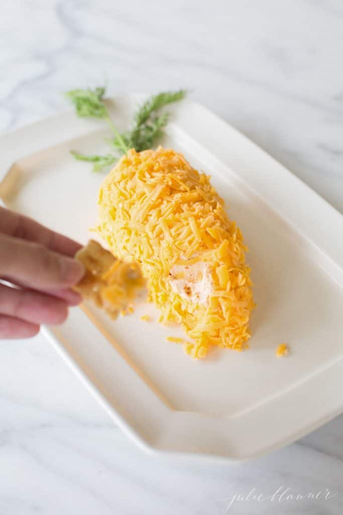 Scooping some of the carrot cheese ball with a cracker