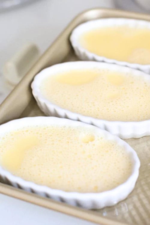An easy baking sheet with three small bowls of creme brûlée.