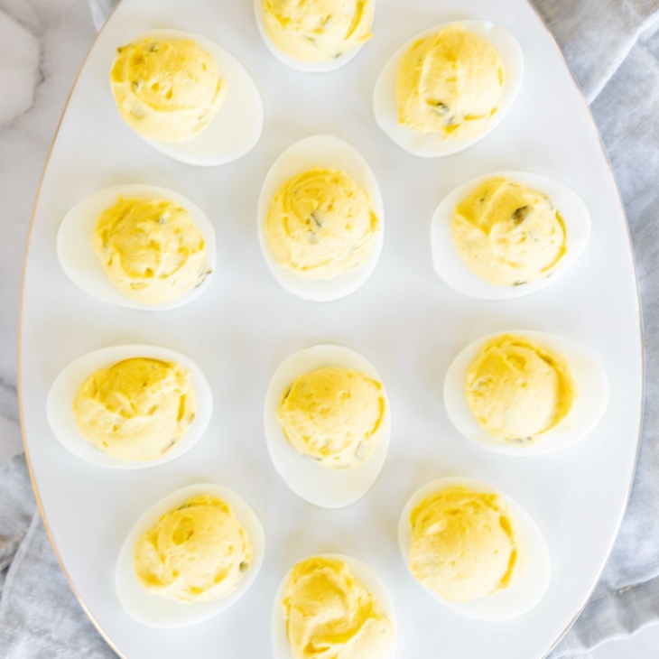 A white deviled egg platter featuring the world's best deviled egg recipe.