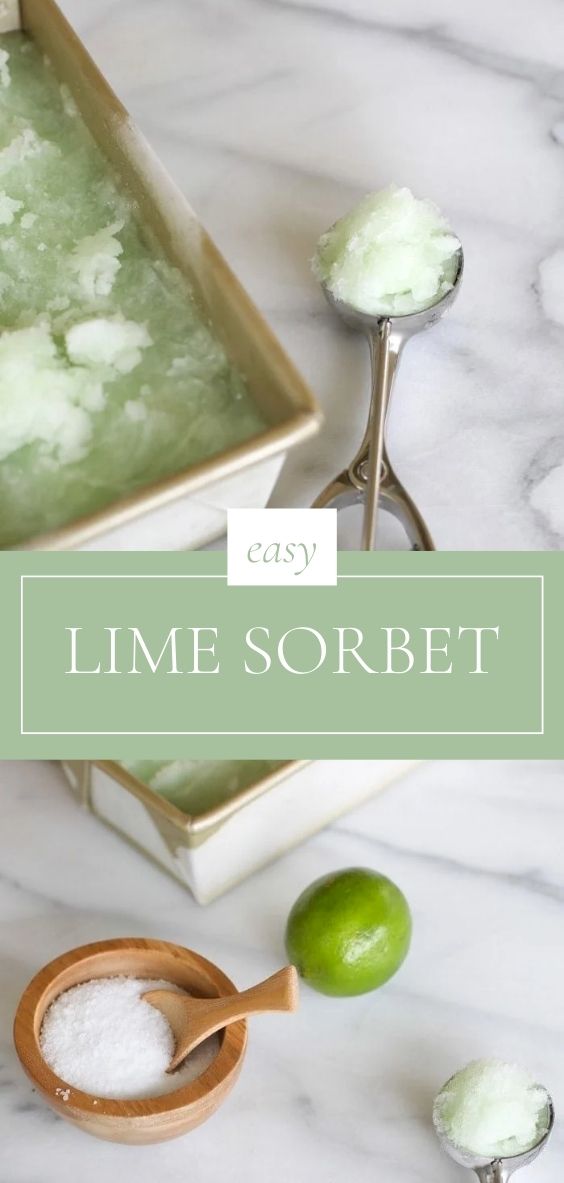 On a marble counter, there is a metal pan of lime sorbet, an ice cream scoop, a lime, bowl of salt.