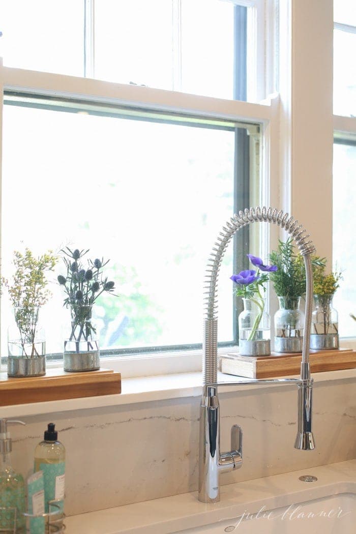 A chrome faucet in a renovated white kitchen of an old home