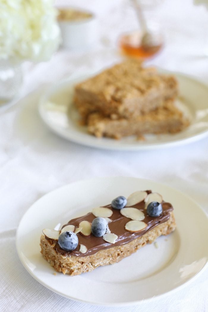 A no bake granola bar topped with chocolate, fruit and nuts