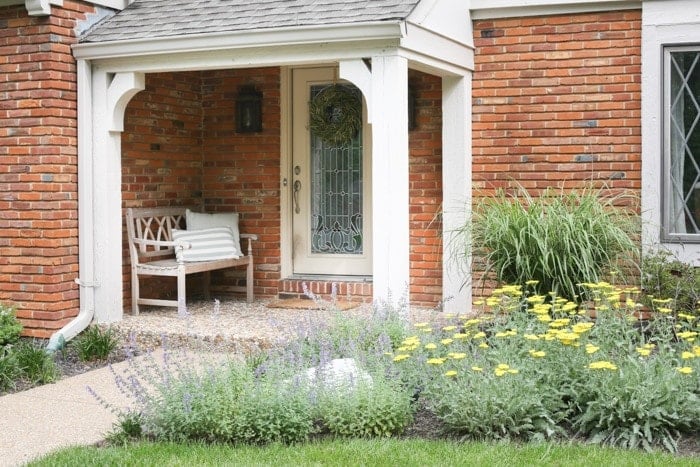A cottage garden in front of a brick tudor home.
