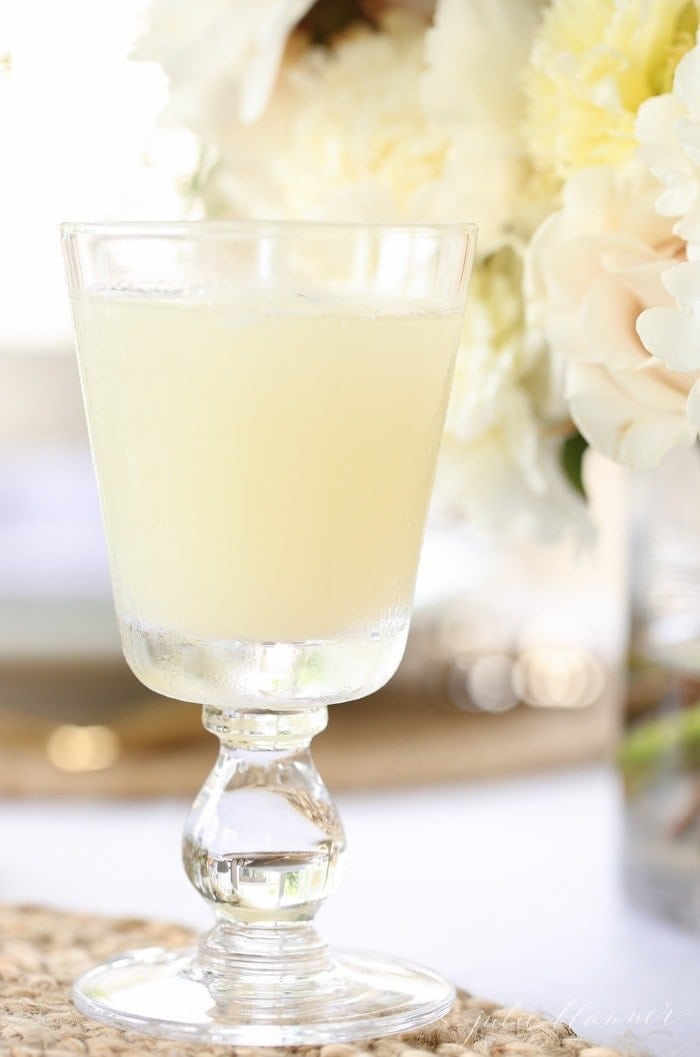 honey lemonade in a goblet with flowers in the background