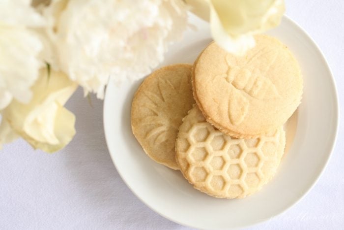 lemon shortbread cookies on a plate with yellow flowers in the corner 