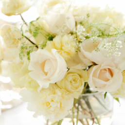 A white peony arrangement in a glass vase.