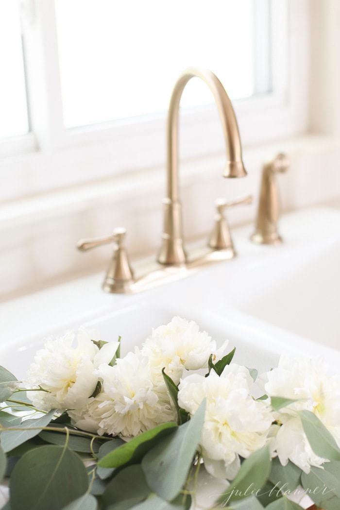 champagne bronze faucet and flowers in an original porcelain sink