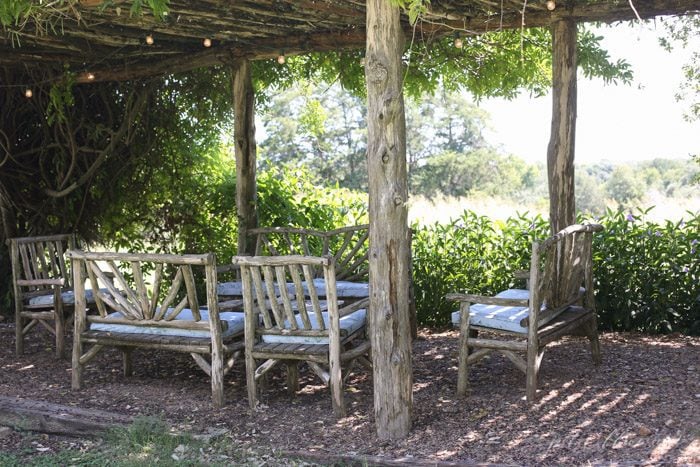 wood patio furniture brick patio with greenery trellis