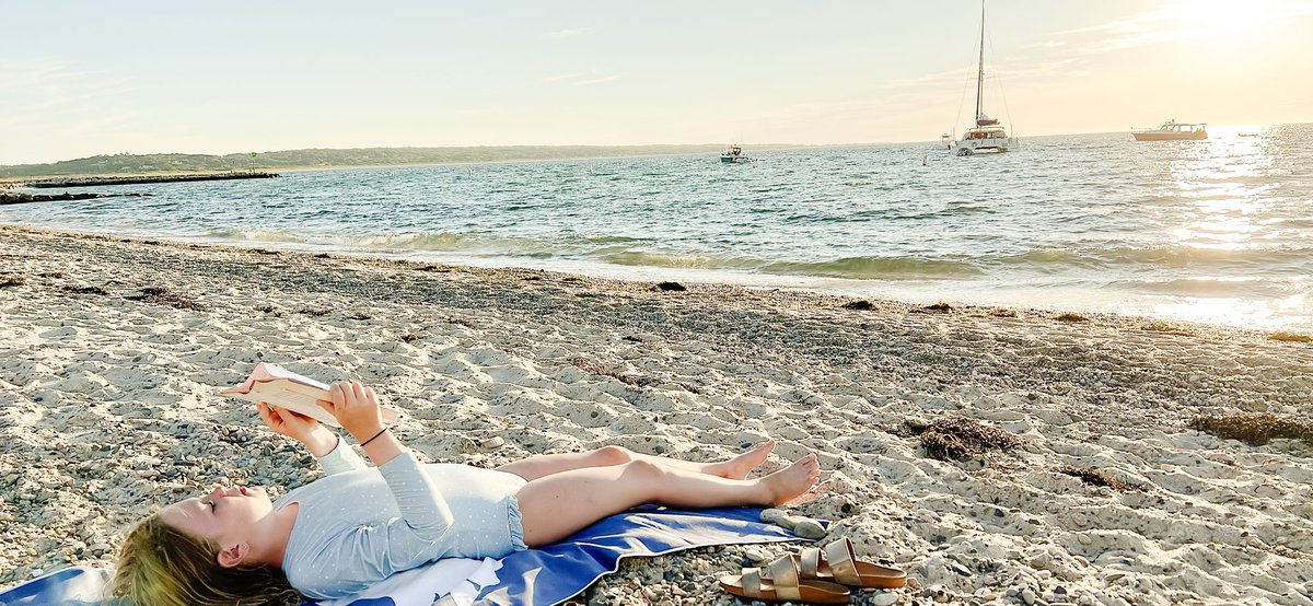 A little girl laying on a towel at sunset on Martha's Vineyard