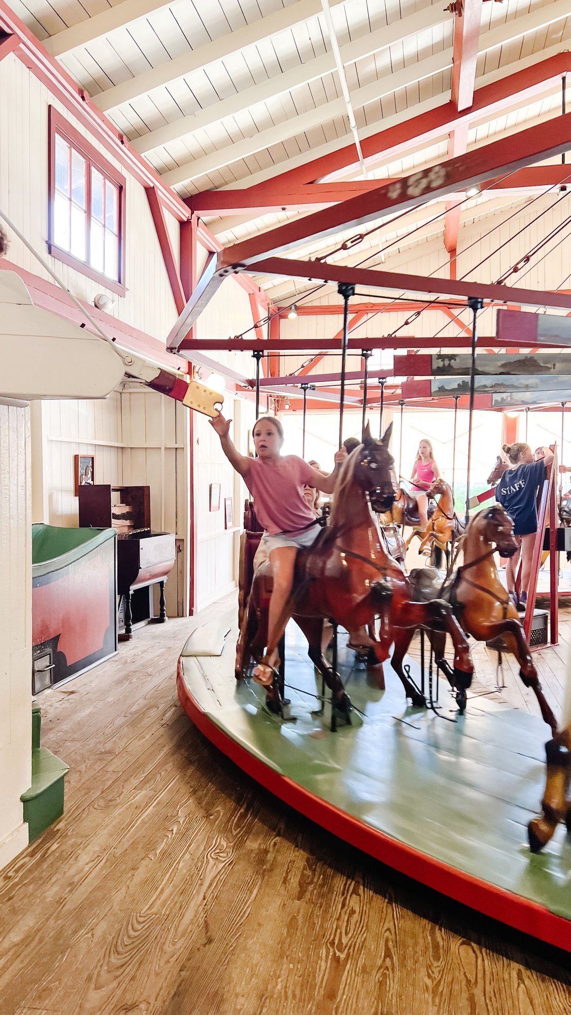 A little girl on a vintage carousel in Martha's Vineyard