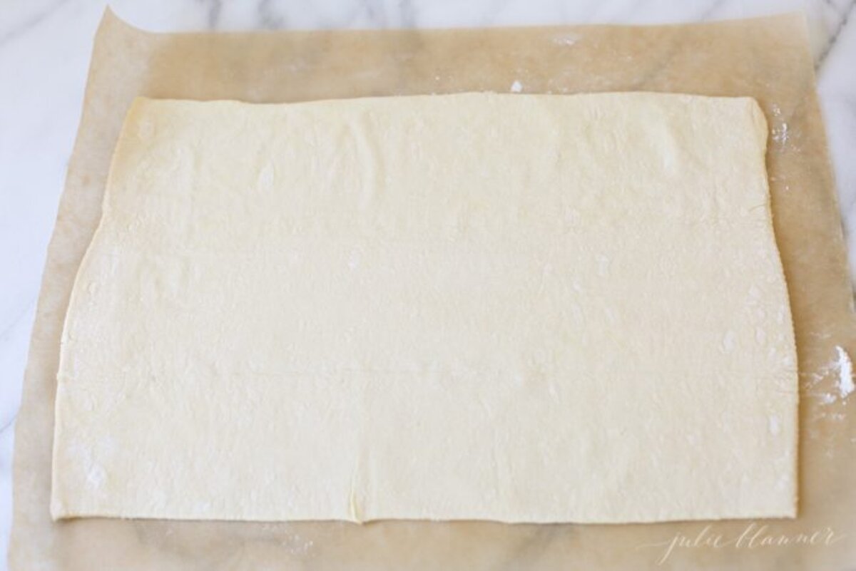 A sheet of puff pastry rolled onto parchment paper