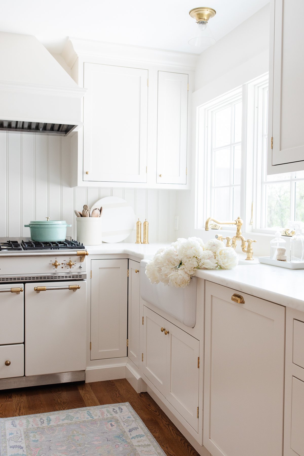 Cream kitchen cabinet with brass knobs in a traditional kitchen. 