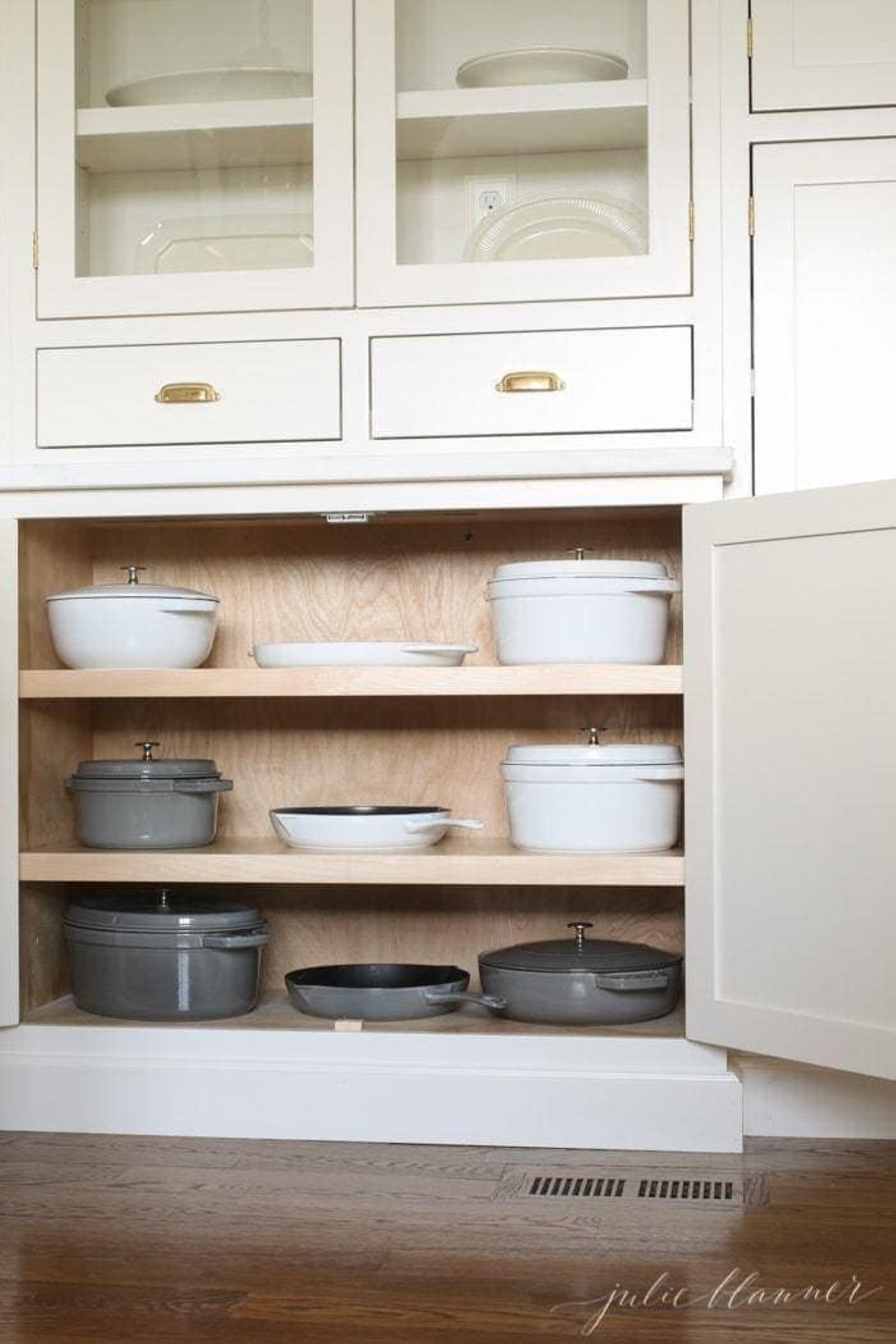 Cast iron pots and pans storage in a shallow home pantry cabinet.