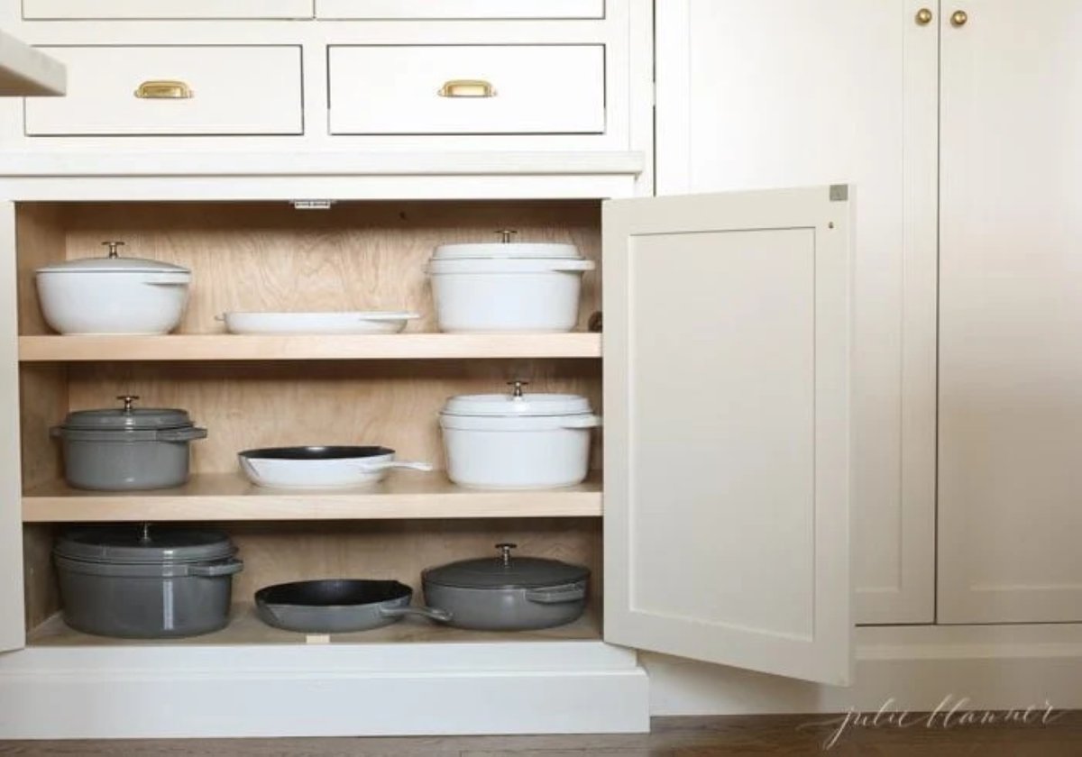 Cast iron pots and pans storage in a shallow home pantry cabinet.
